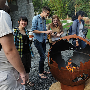Smiling students around a campfire