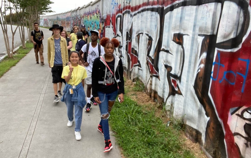 First Year Seminar students walk along a wall of graffiti in East Atlanta.