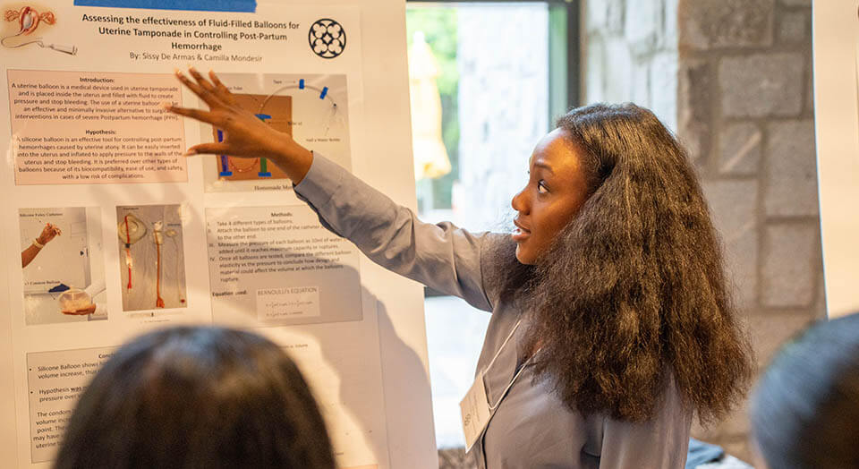 A student explains their research during the poster session for LASS 2023.
