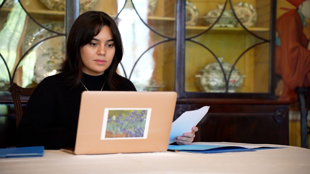 Studio art major Sophia Sobrino sits at a computer in the dining room of the May Patterson Goodrum House