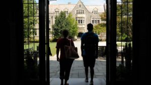 Students exit doorway opening toward Hearst Hall