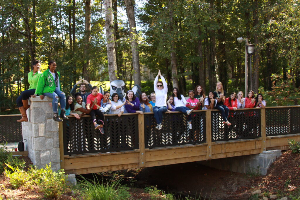 Greek life members assembled with Petey on the TLCC bridge