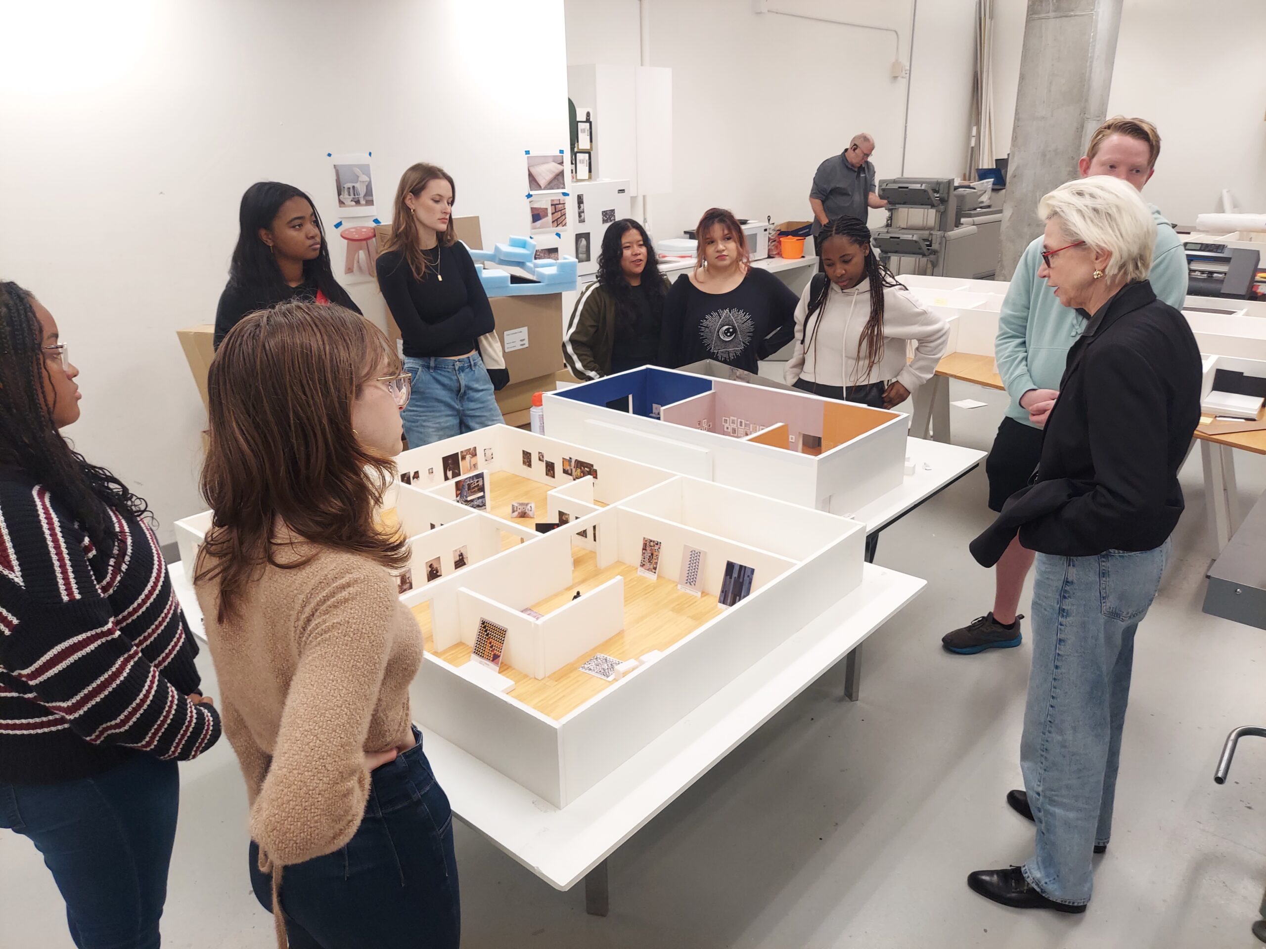 Students gathered around a scale moden with Dr. Claudia Einecke