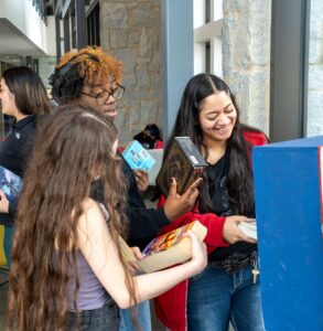 Students stock a little library with books