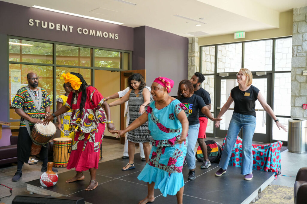 Manga Dance groups performing with Oglethorpe faculty and staff on stage at the Juneteenth event.