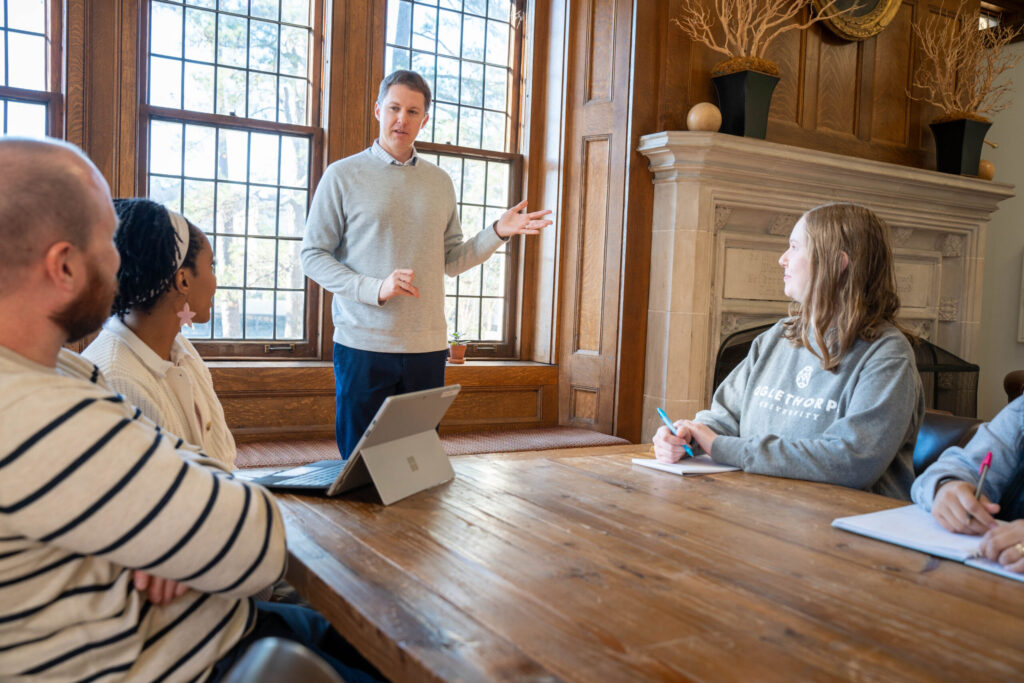 Financial Aid Director Chris Summers stands at a table talking to a group of people