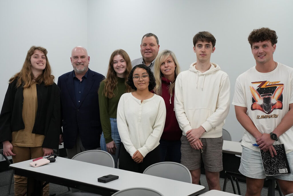 Hammack School of Business Investment students and instructors standing in a row in a classroom.