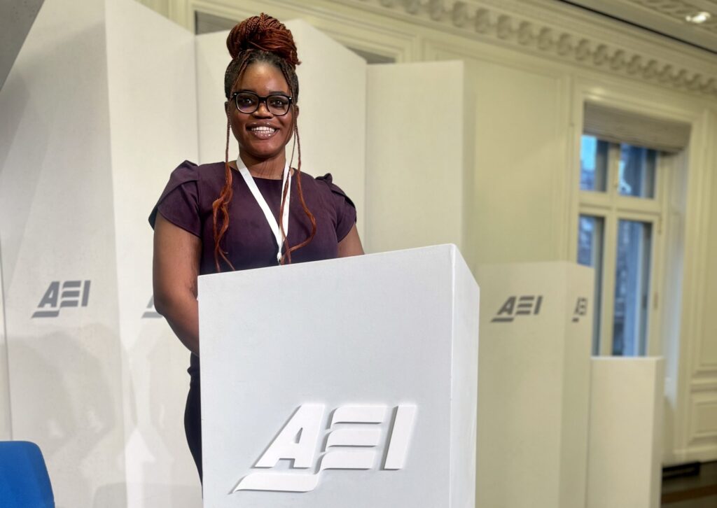 Gloria Okueze at a podium that bears the American Enterprise Institute's Logo