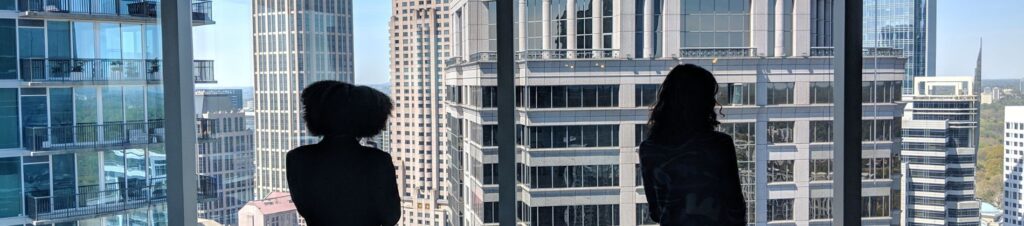 Two women look out of a high rise in Atlanta.