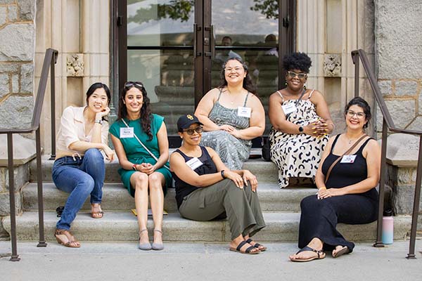 Alumni sit on the steps of Lupton Hall