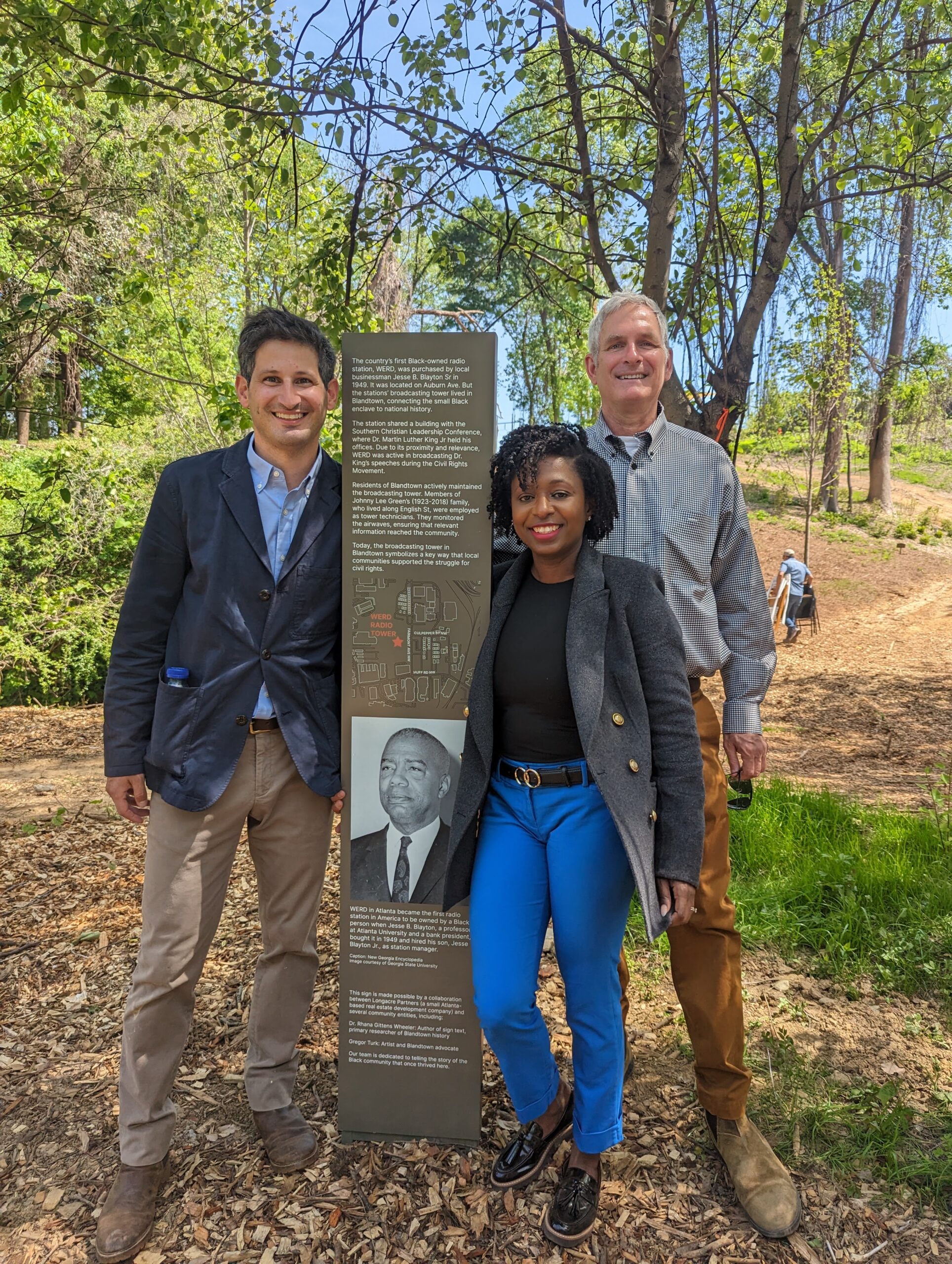 Dr. Rhana Gittens Wheeler poses next to one of the signs she authored at Blandtown in Atlanta