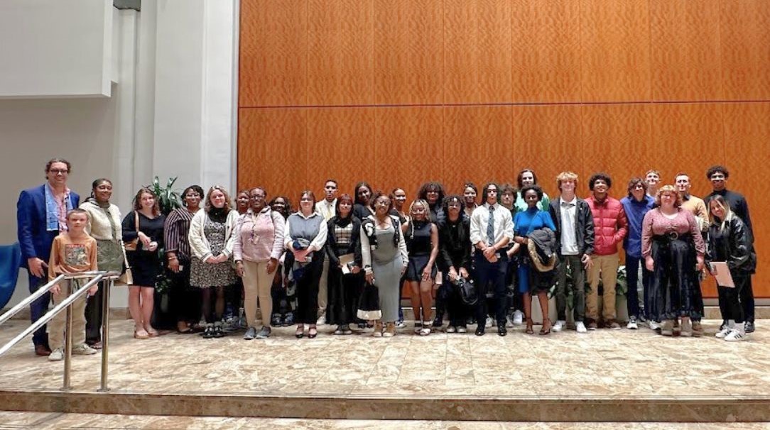 A group of students and professors attending an Atlanta Symphony Orchestra concert standing in the Woodruff Arts Center