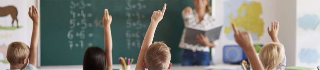 Kids raising their hands in educational class