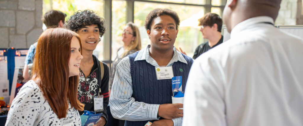 Diverse students speak with a recruiter at the career fair 2024.