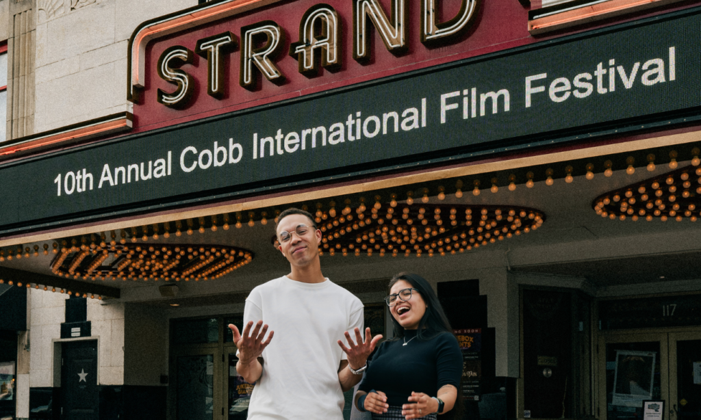 Justin Edwards and Karla Ojeda pose in front of the Earl and Rachel Smith Strand Theatre.