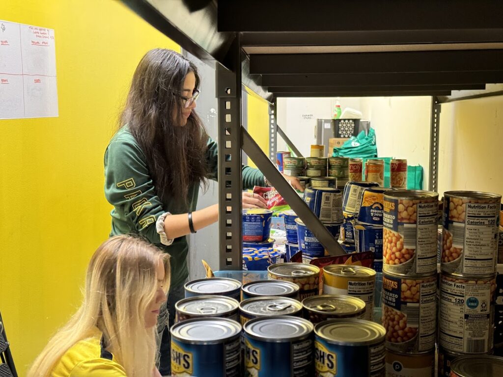 Two students organizing food items in Oglethorpe's food pantry.