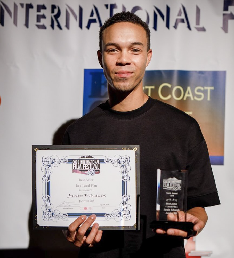 Justin Edwards holds his award and certificate for "Best Actor in a local film" from the Cobb International Film Festival.