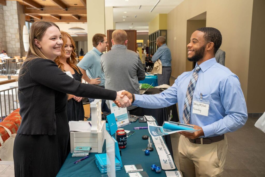 A student and a recruiter shake hands at Oglethorpe's career fair