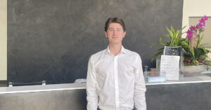 A young man in front of the NCR reception desk