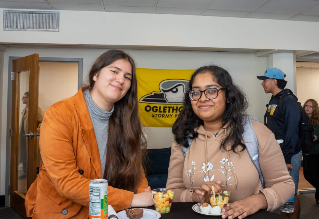 Two students pose for a photo inside the commuter lounge.