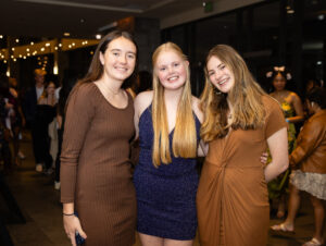 Three students dressed in formal attire at the 2023 Boar's Head student party.