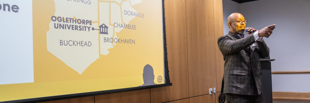 Man in a suit with microphone pointing