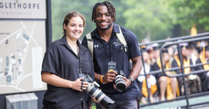 Melanie Davis and Ben Schick take photos at Commencement 2024.
