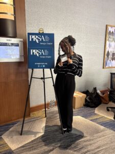 Ivy Nganga '26 next to the PRSA poster