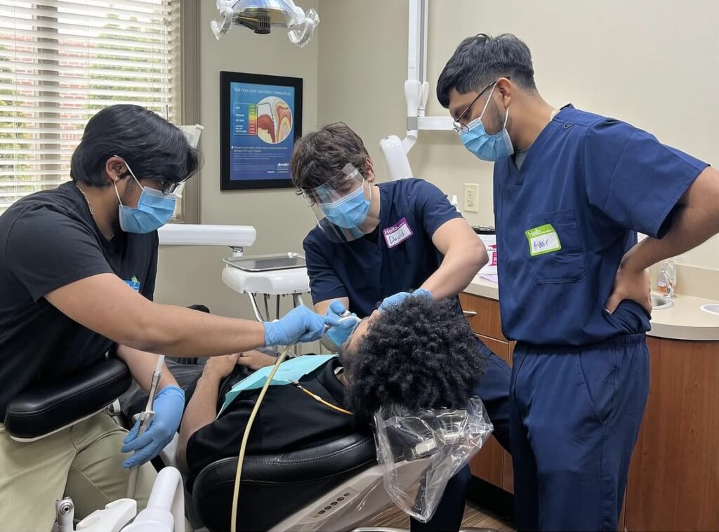 Pre-Dental Club members practicing with dental assistant tools.