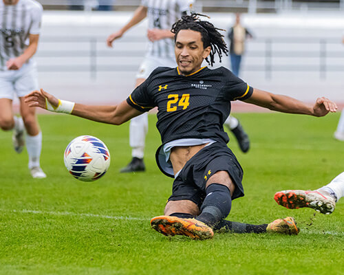 An athlete kicking a soccer ball.