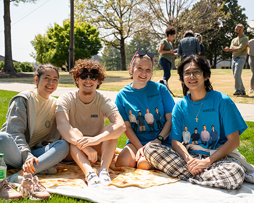 A group of students sitting on a lawn