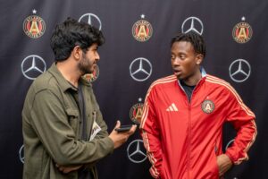 A student interviews a soccer player