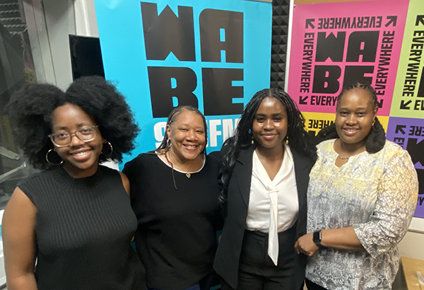 Four women in front of a banner that says WABE
