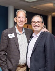 Two men stand and pose for a photo.