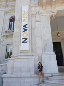 Woman stands in front of Lisbon building.
