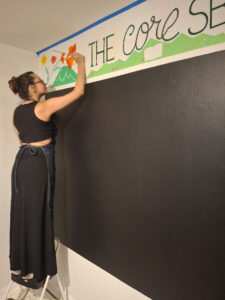 Student painting a mural that says "The Core self."