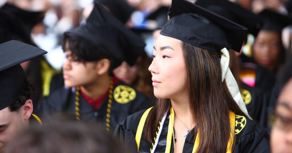 A graduating student observes the ceremony, looking hopeful
