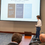 Two students presenting. They have suits on.