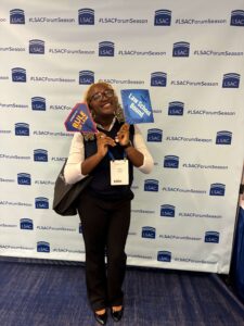 Student in professional attire while holding photobooth prop that reads "law school bound."