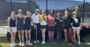 Group of adults in front of the tennis courts.