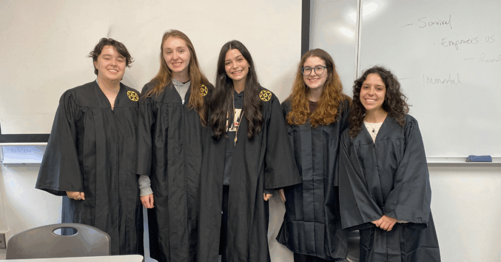 A group of students stand together smiling.