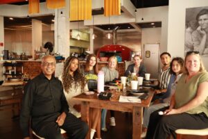 Students sit at a table meeting with their client
