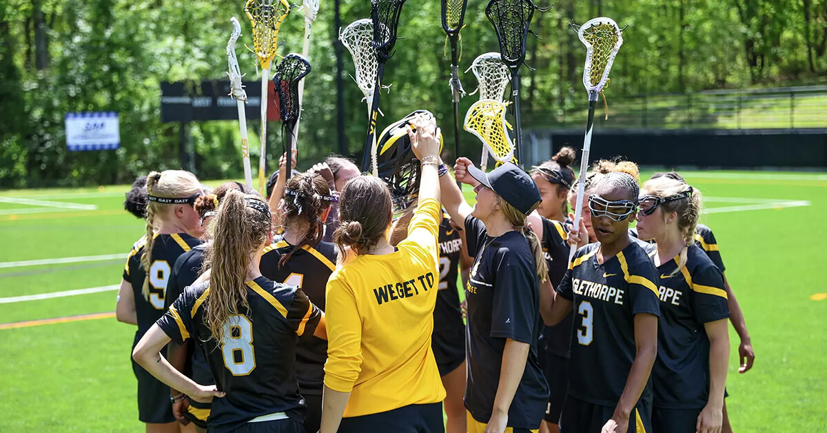 Women's lacrosse team putting their nets up as a chant