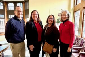 Group of four poses for camera.