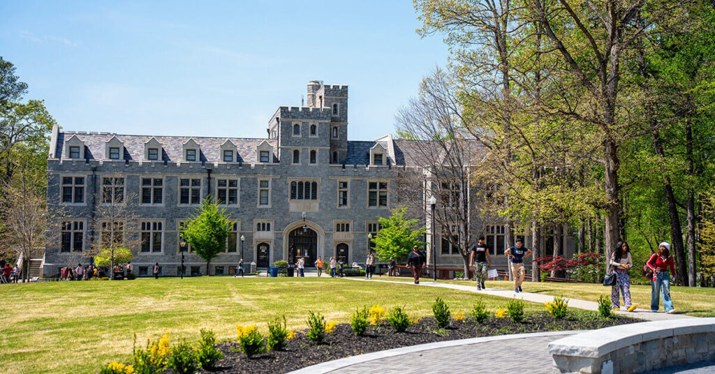 Students walk across campus in front of Lowry Hall