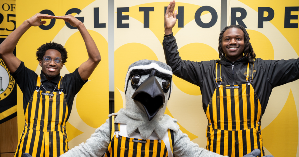 Petey and two students wearing black and yellow overalls at Oglethorpe Day 2025.