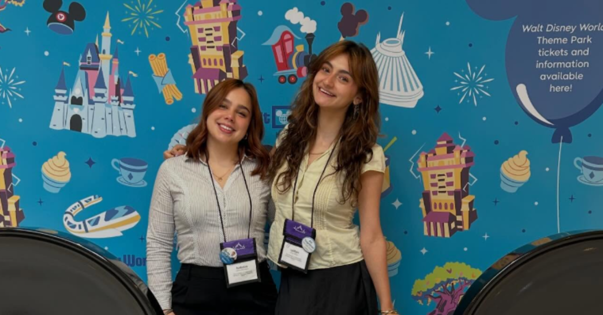 Two students pose smiling