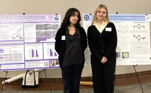 Two students pose in front of their research posters at the Georgia State Capitol