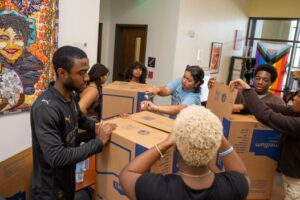 A group of students assemble boxes at a meal packing event