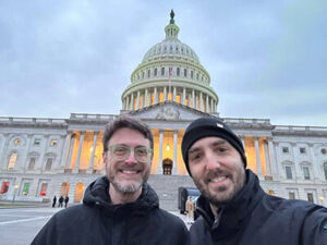 Eli Arnold and his husband stand in front of the Library of Congress.